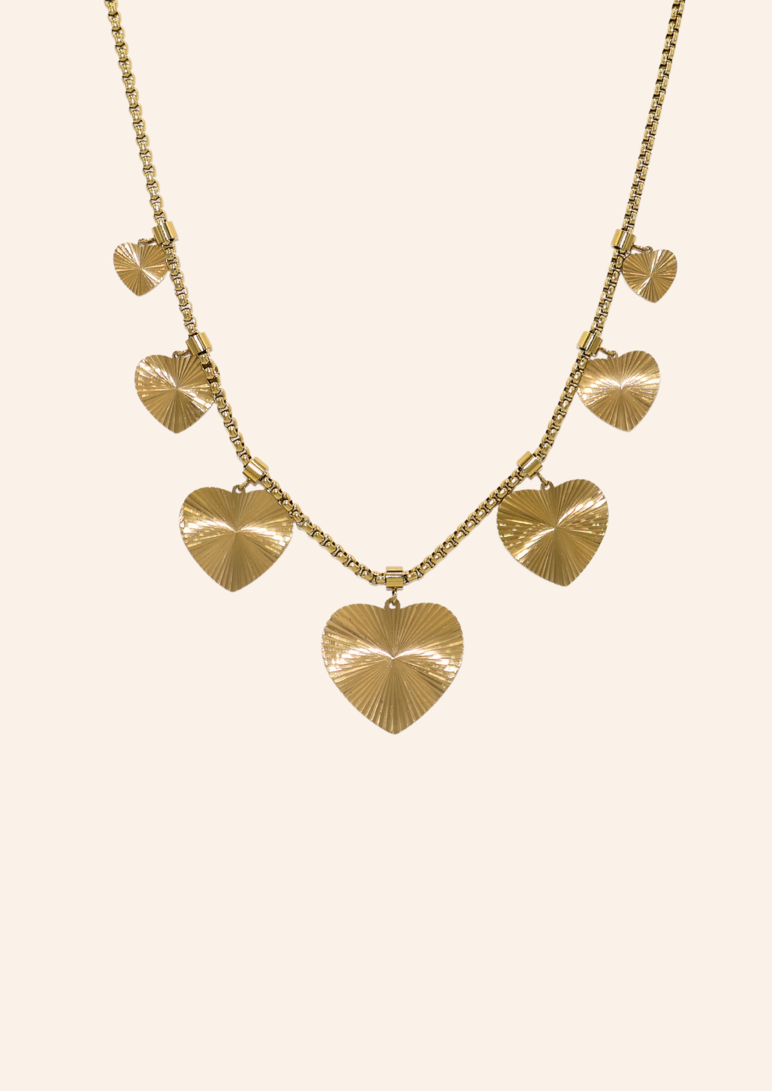 Gouden ketting van roestvrij staal met hartjesbedels. Verkrijgbaar op izzithelabel.nl. De ketting verkleurt niet door water.