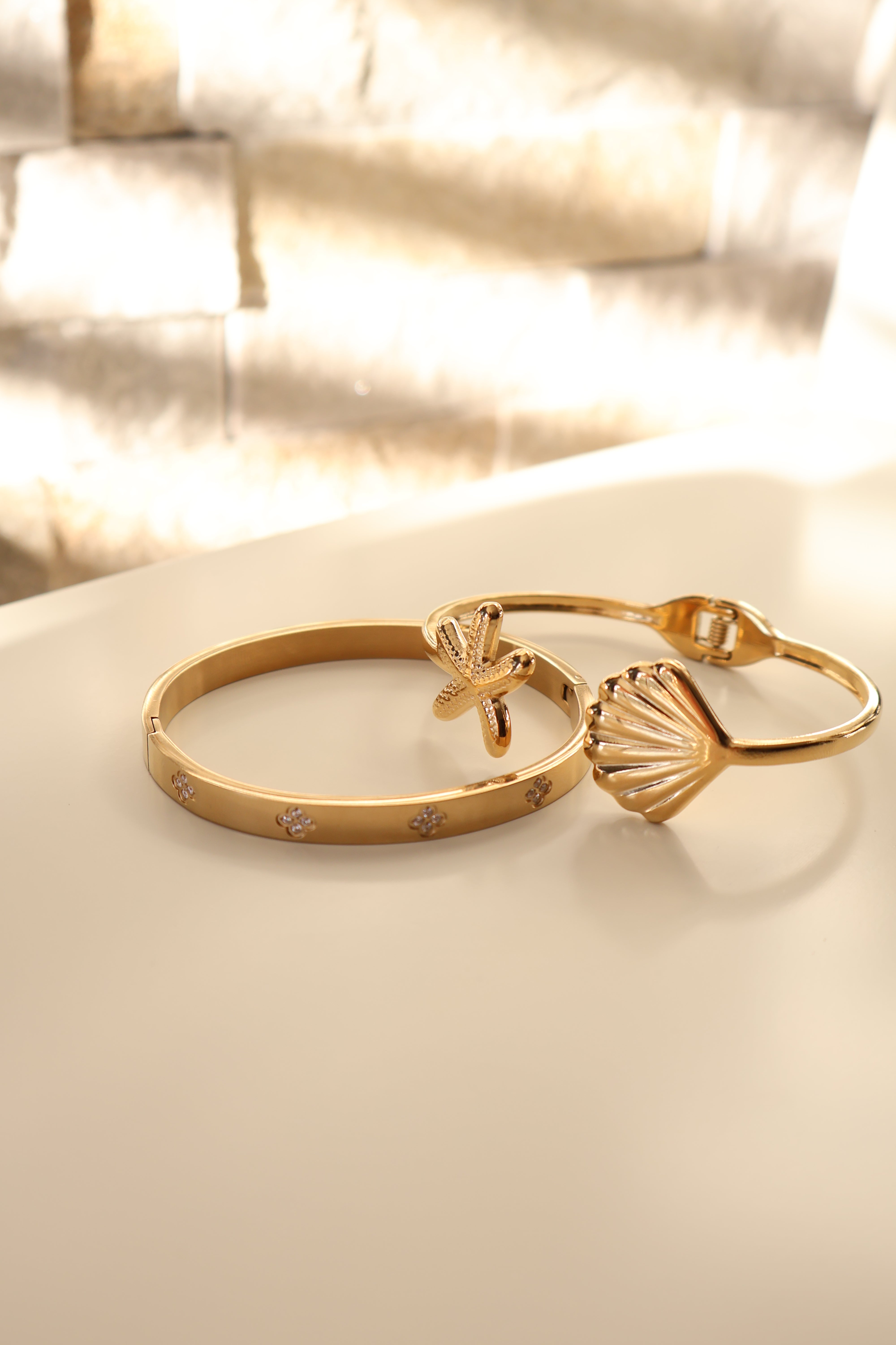 Gouden bangle met schelp en ster. Gemaakt van stainless steel dus is waterproof en hypo-allergeen.