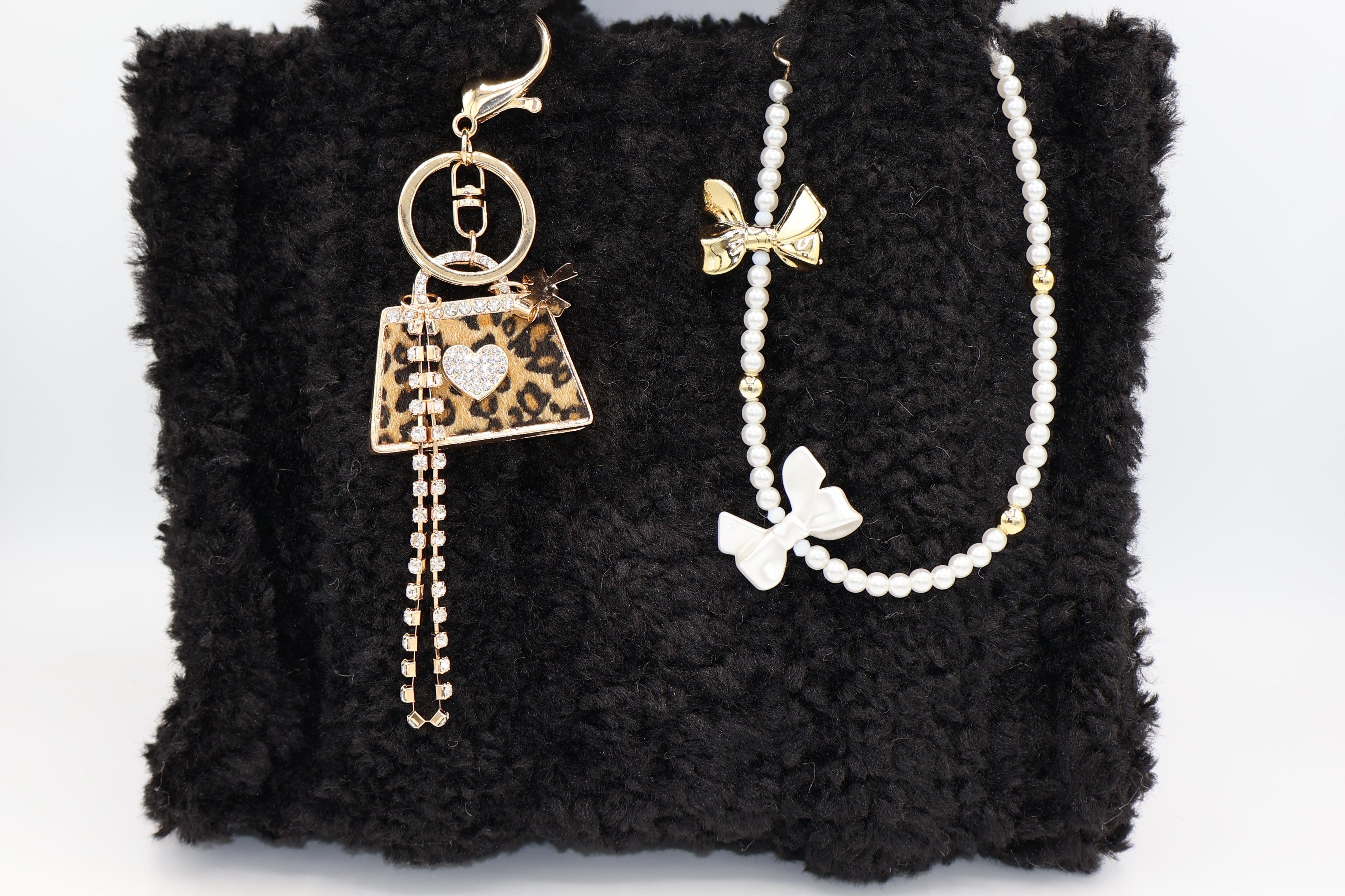 Tassenbedel met witte en gouden strikje om je tas te pimpen. Verkrijgbaar bij izzithelabel.nl als bagcharm.