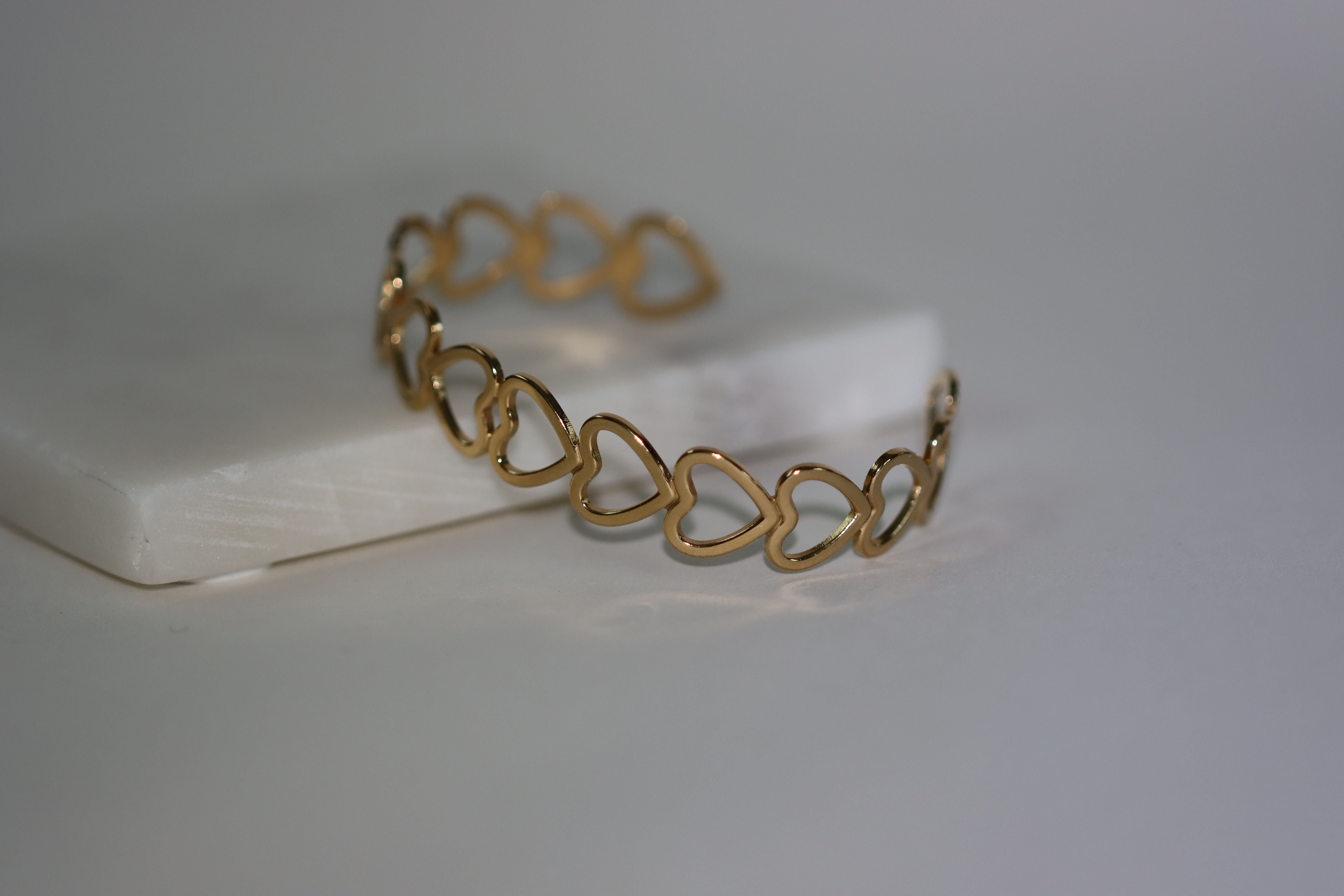 Chunky gouden bangle met hartjes design. Gemaakt van stainless steel dus is waterproof en hypo-allergeen.
