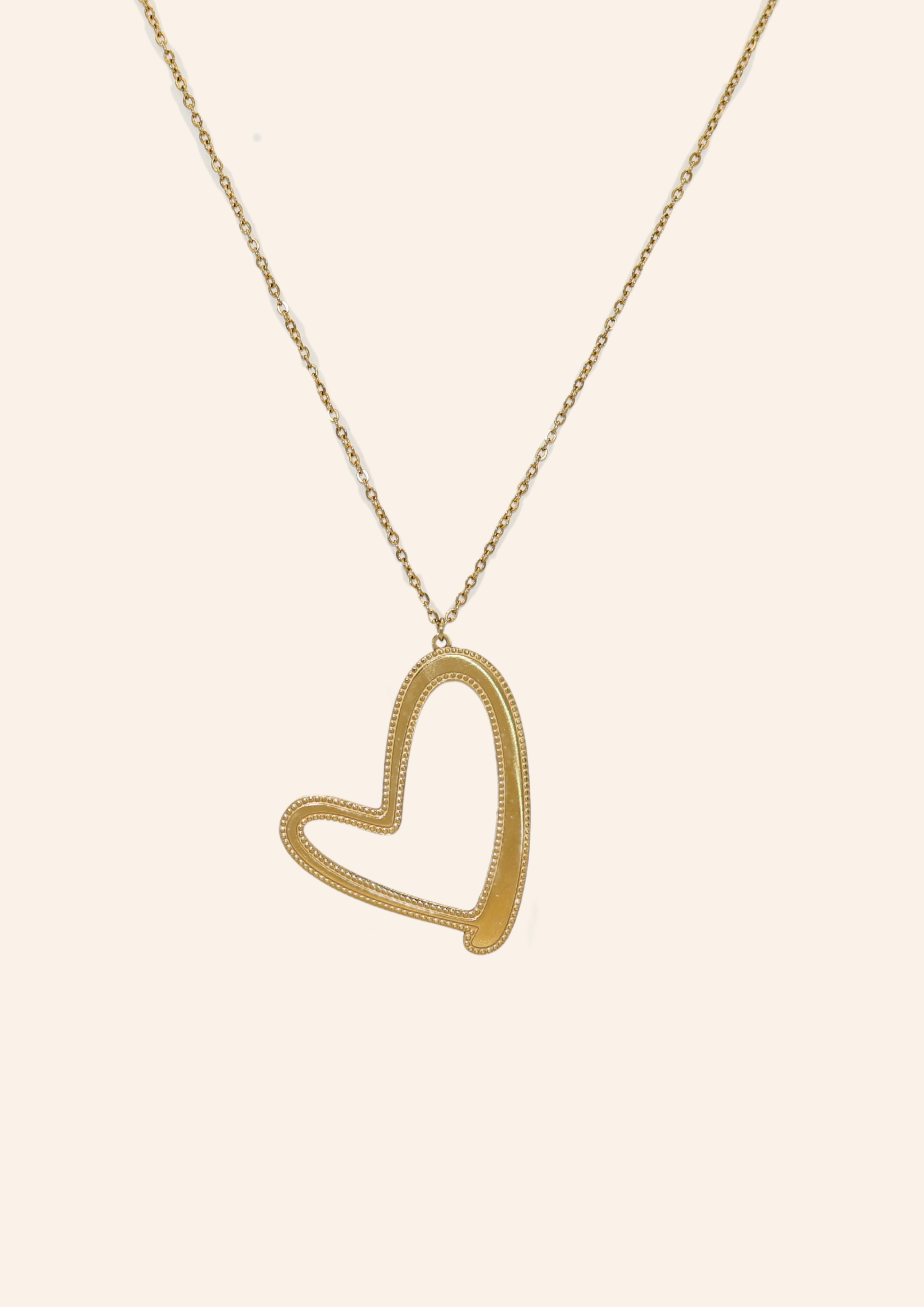 Gouden ketting van roestvrij staal genaamd so over you necklace. De ketting is lang en heeft een statement hartje als bedel. Verkrijgbaar op izzithelabel.nl. De ketting verkleurt niet door water en is stainless steel en nikkelvrij.