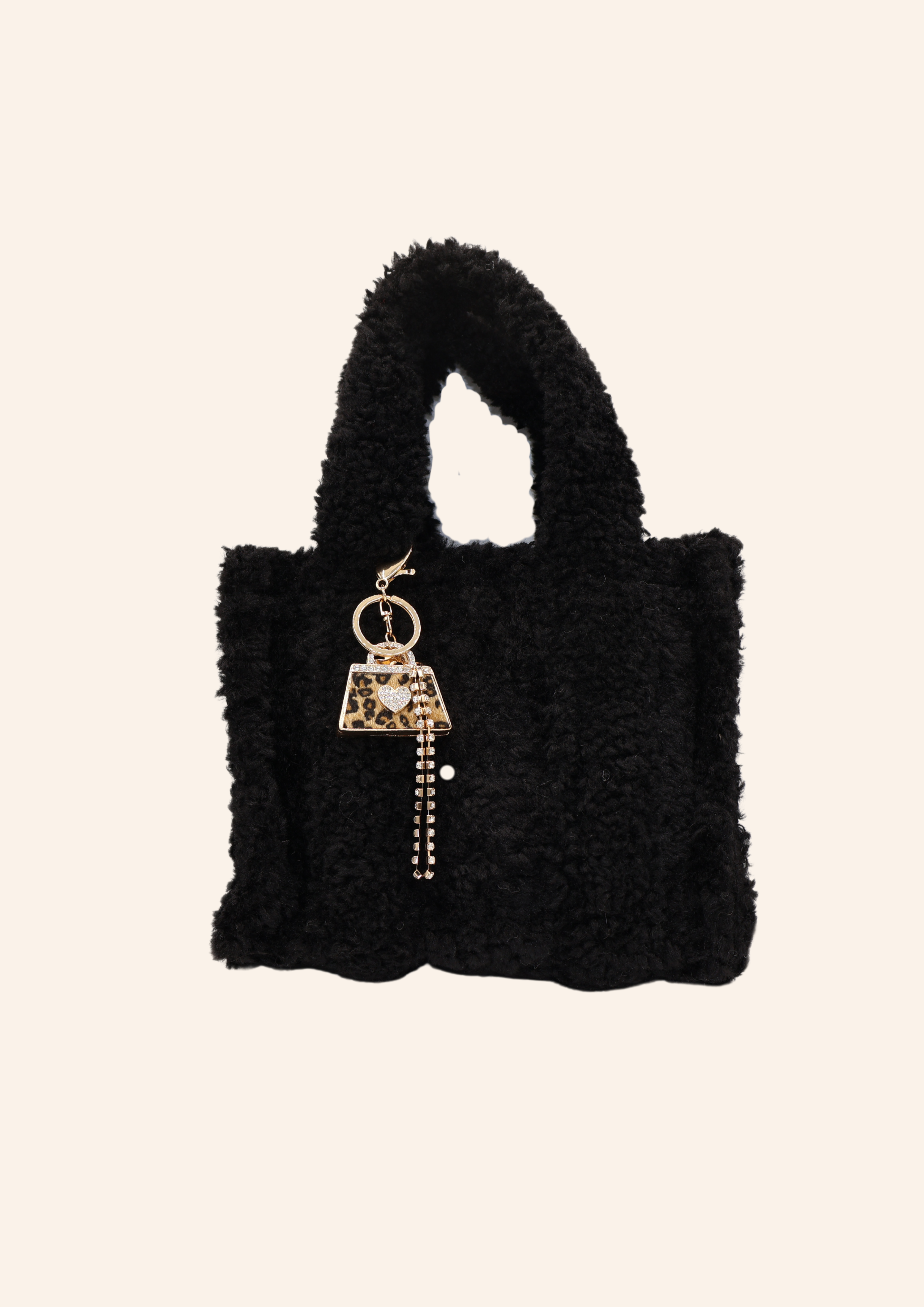 Zwarte teddystof tas. Tas heeft de vorm van een Tote bag en is gemaakt van fluffy, zachte stof. De tas is te combineren met tassenbedels. Verkrijgbaar op izzithelabel.nl