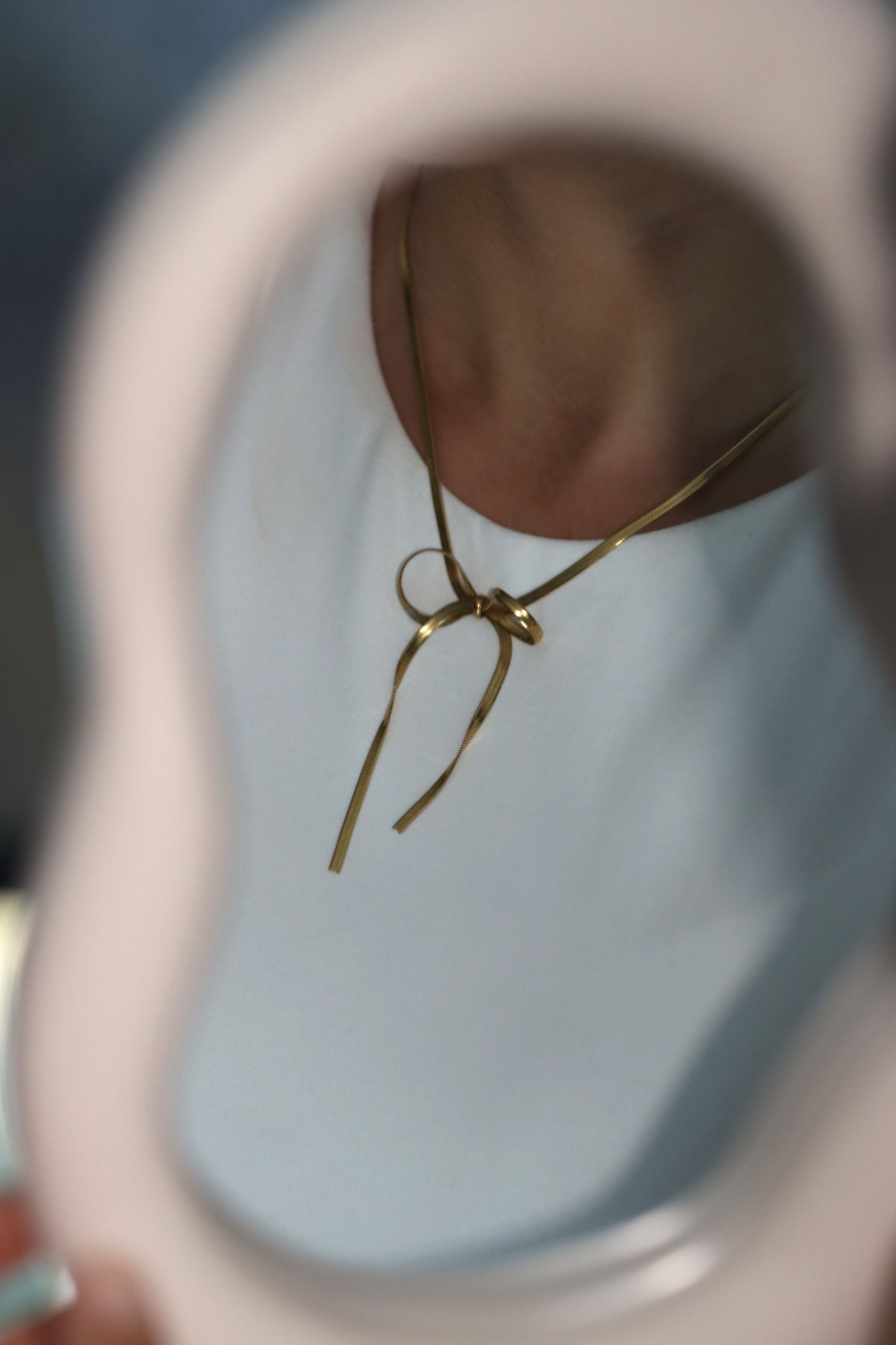 Gouden ketting van roestvrij staal met een strikje eraan. Verkrijgbaar op izzithelabel.nl. De ketting verkleurt niet door water en is stainless steel en nikkelvrij.