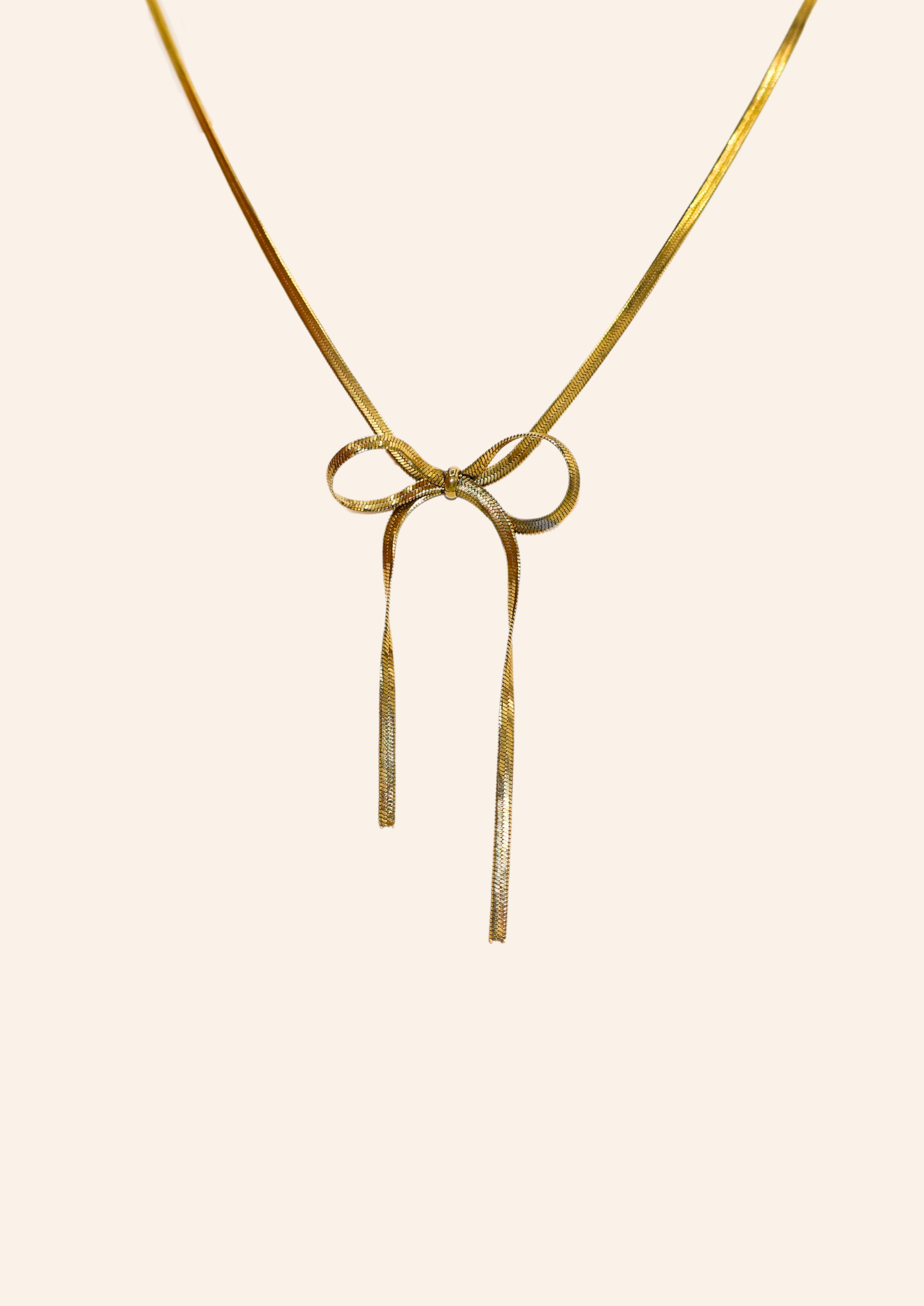 Gouden ketting van roestvrij staal met een strikje eraan. Verkrijgbaar op izzithelabel.nl. De ketting verkleurt niet door water en is stainless steel en nikkelvrij.