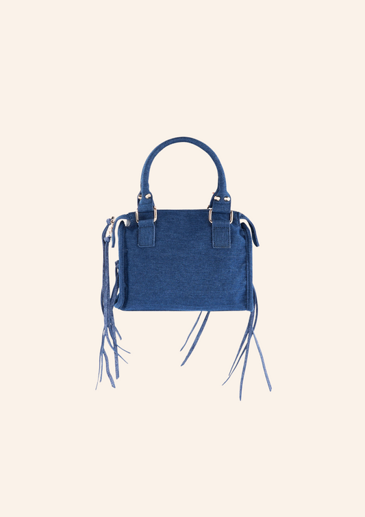 Donkerblauwe denim schoudertas met franjes en fringes. De tas heeft een vintage spijker look en heeft een ritssluiting. Wordt verkocht op izzithelabel.nl.
