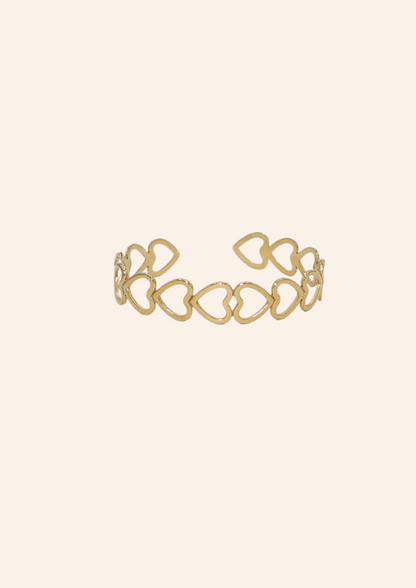 Chunky gouden bangle met hartjes design. Gemaakt van stainless steel dus is waterproof en hypo-allergeen.