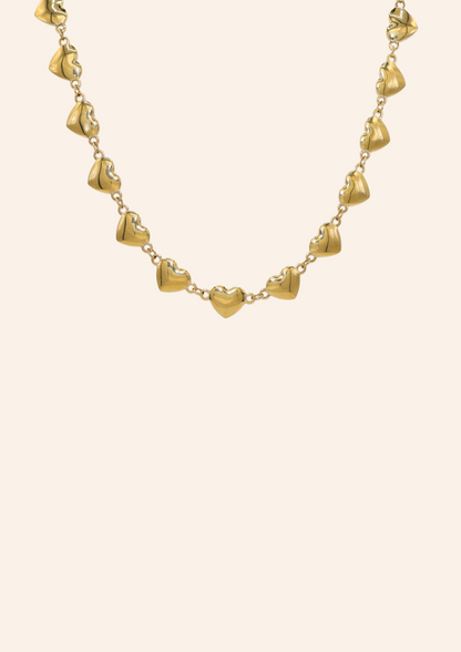 Gouden ketting van roestvrij staal met hartjes aan elkaar verbonden. Verkrijgbaar op izzithelabel.nl. De ketting verkleurt niet door water en is stainless steel en nikkelvrij.