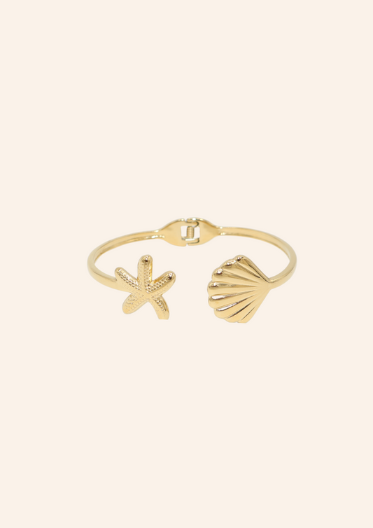 Gouden bangle met schelp en ster. Gemaakt van stainless steel dus is waterproof en hypo-allergeen.
