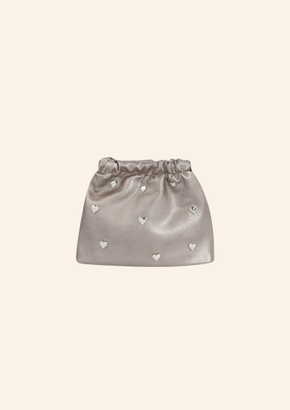 Metallic zilver kleurige schoudertas met hartjes studs. De tas heeft een leather look en heeft een druksluiting. Wordt verkocht op izzithelabel.nl.