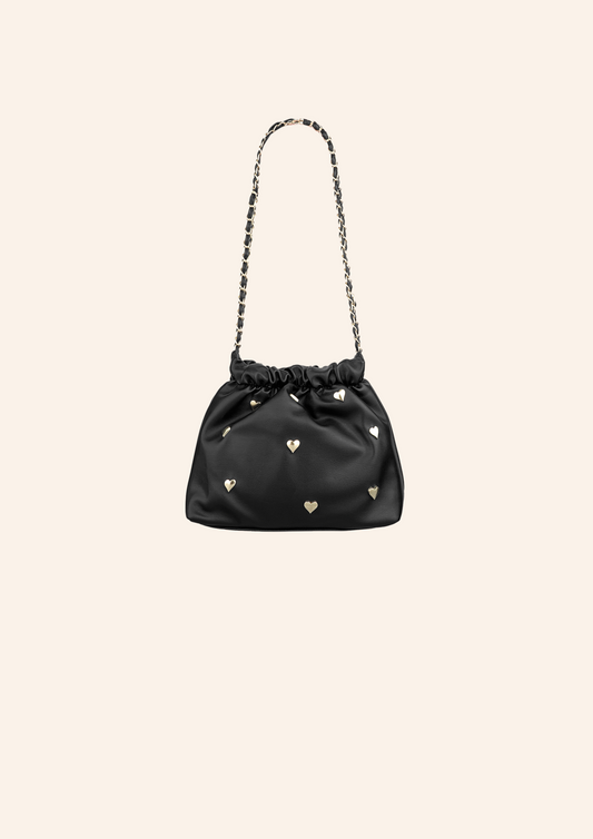 Zwart kleurige schoudertas met hartjes studs. De tas heeft een leather look en heeft een druksluiting. Wordt verkocht op izzithelabel.nl.