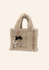 Beige teddystof tas. Tas heeft de vorm van een Tote bag en is gemaakt van fluffy, zachte stof. De tas is te combineren met tassenbedels. Verkrijgbaar op izzithelabel.nl.