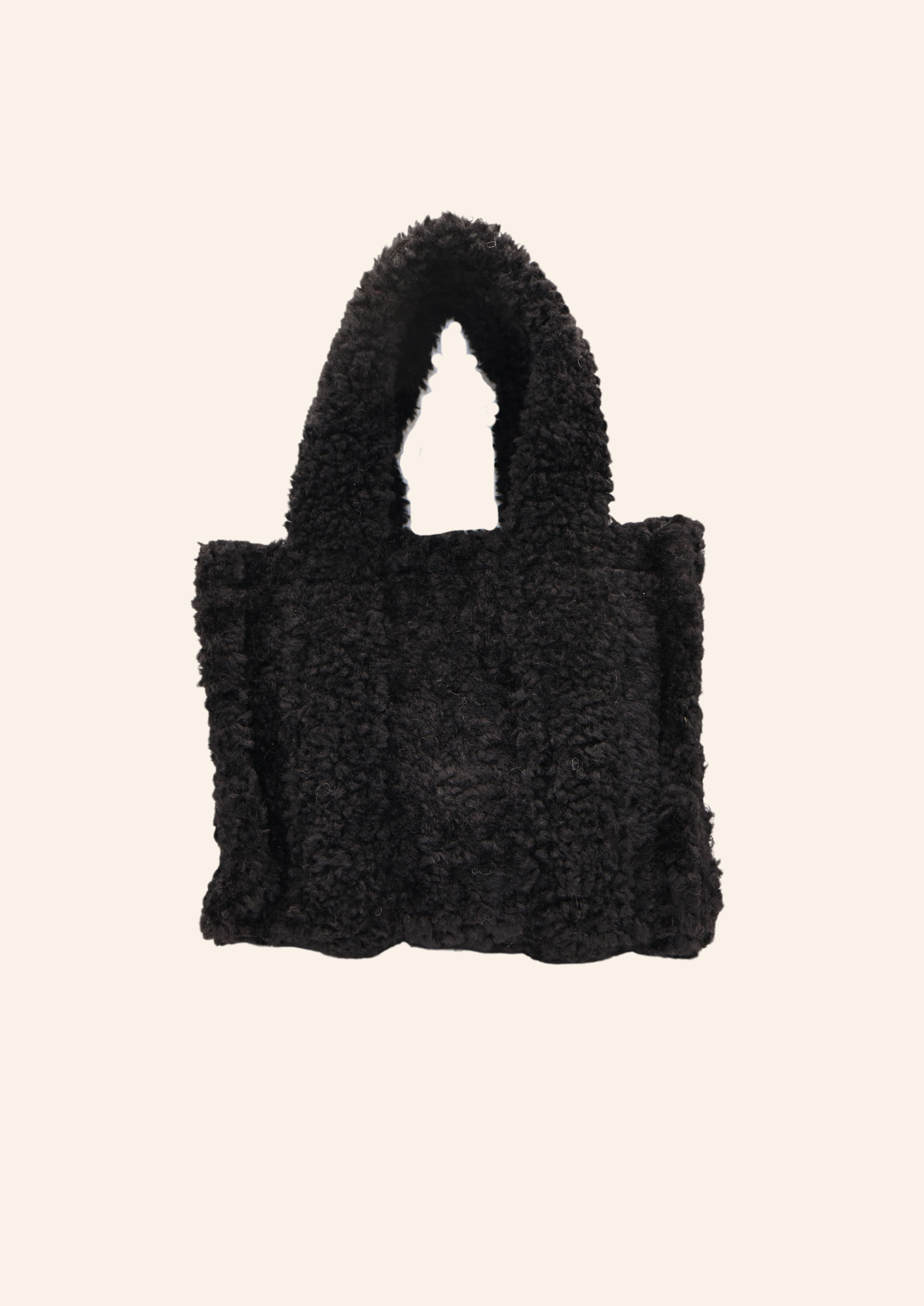 Zwarte teddystof tas. Tas heeft de vorm van een Tote bag en is gemaakt van fluffy, zachte stof. De tas is te combineren met tassenbedels. Verkrijgbaar op izzithelabel.nl