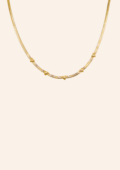 Gouden ketting van roestvrij staal genaamd triple the love necklace. De ketting heeft kleine hartjes. Verkrijgbaar op izzithelabel.nl. De ketting verkleurt niet door water en is stainless steel en nikkelvrij.